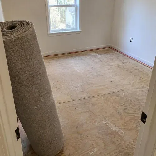 Tack strip installed around a plywood subfloor before carpet installation