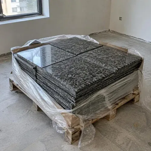 Pallet of dark speckled granite floor tiles ready for installation
