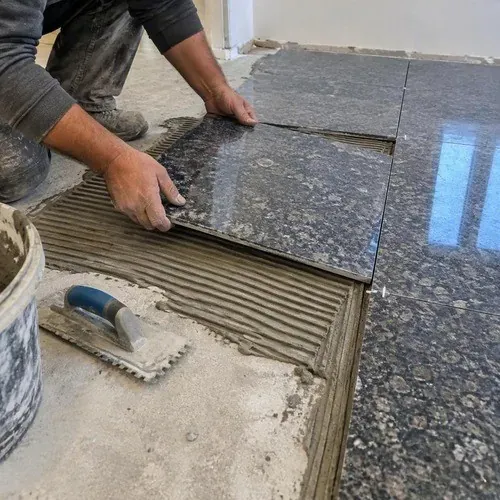 Granite floor tile back-buttered and set on notched thinset