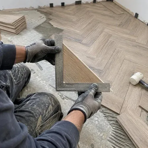 Installer checking a herringbone block with a square before gluing
