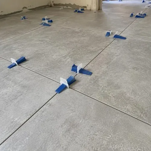 Leveling clips controlling lippage between large-format floor tiles