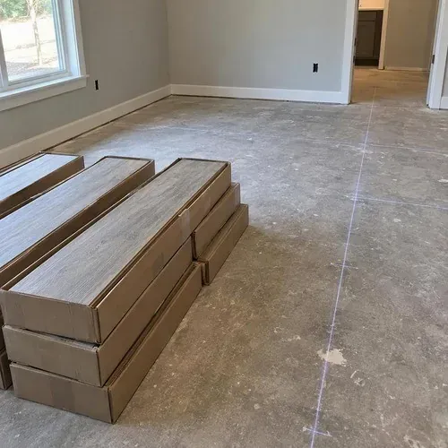 Boxes of wood-look porcelain tile planks beside layout lines