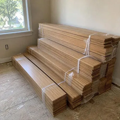 Bundles of strand-woven bamboo flooring acclimating near a window before installation